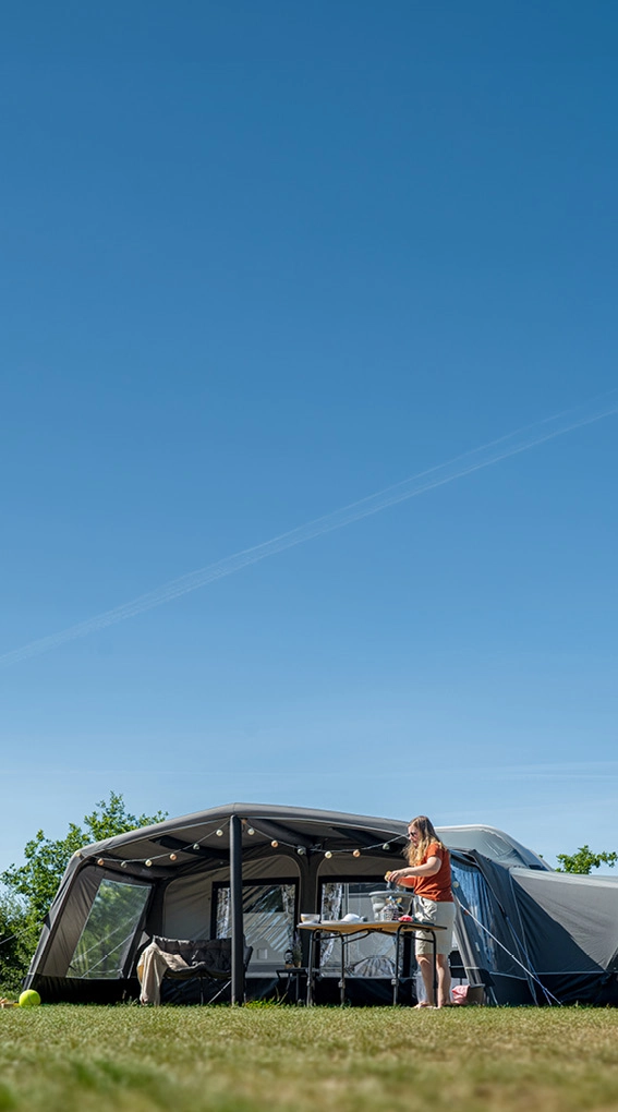 Auvent de camping-car avec cuisine extérieure sous ciel ensoleillé